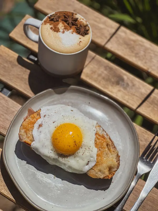 Egg tartine with a rosemary latte on a wooden table